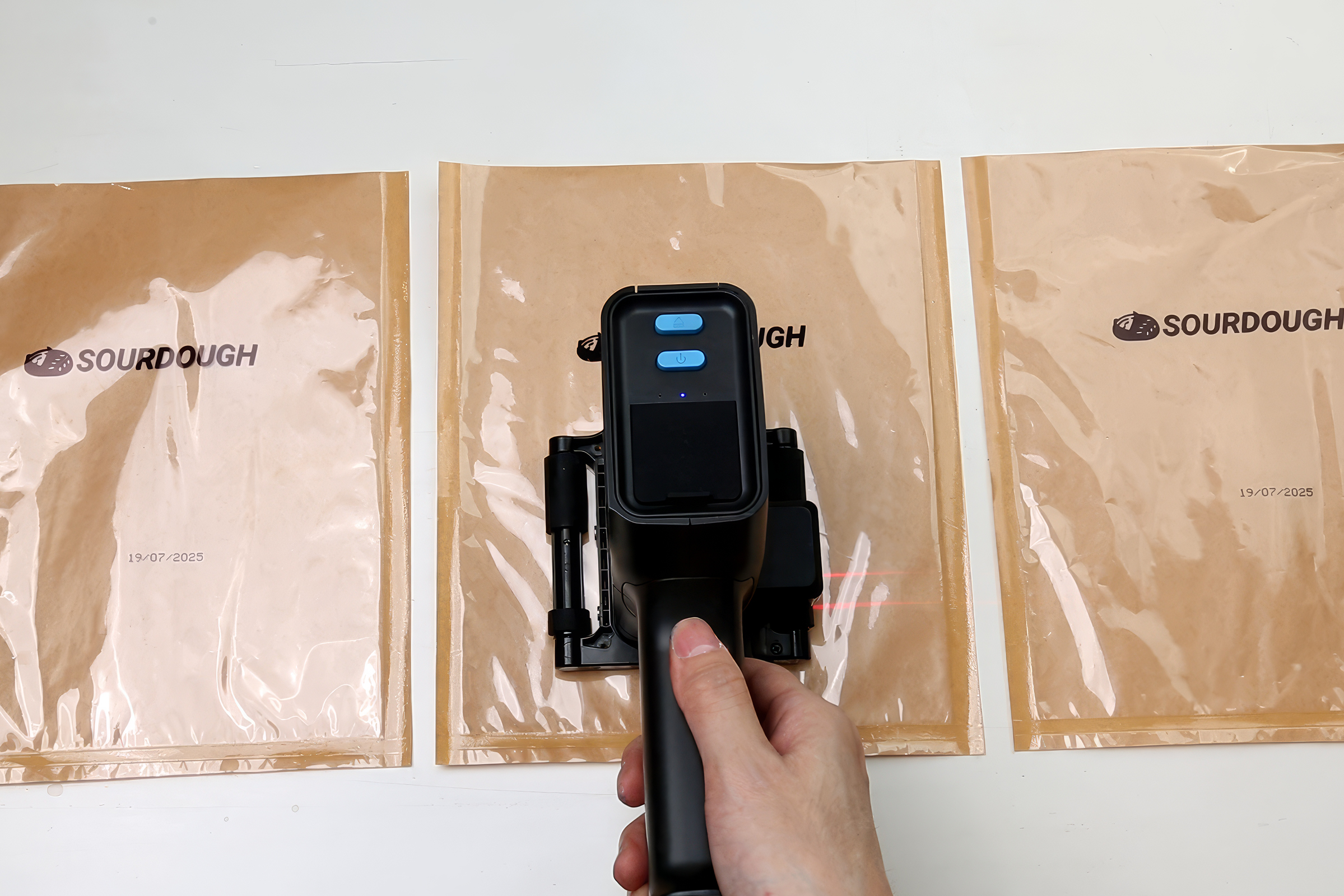 Laser-guided date code printer marking sealed food packaging bags