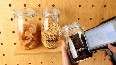 Handheld inkjet printer marking labels on curved glass containers