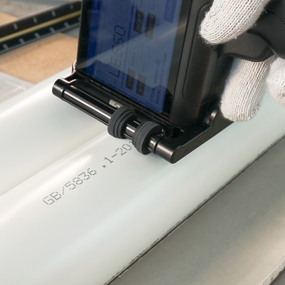 Pipe code printer marking production data on white plastic pipe